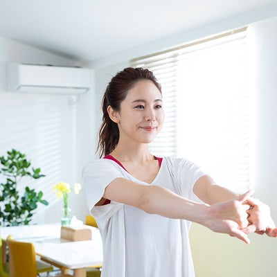 女性が組んだ手を伸ばしてストレッチをする様子
