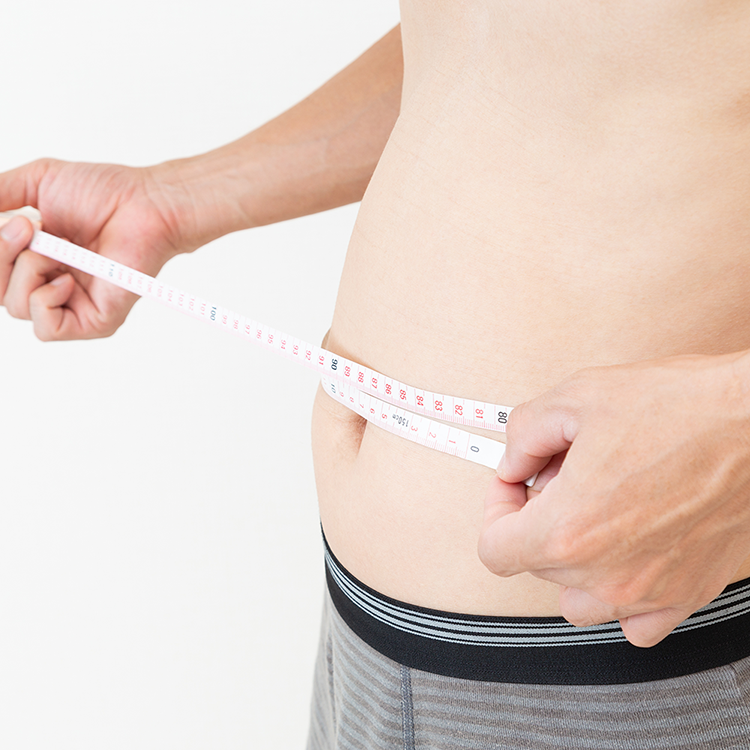 腹部の脂肪を測定している男性の画像