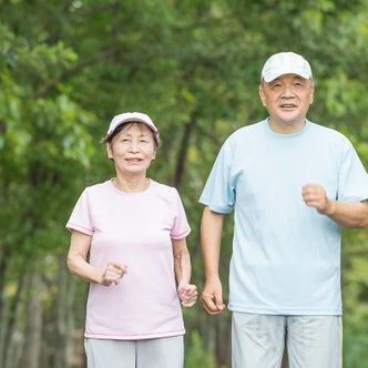 シニア世代の男性と女性が屋外でランニングをしている様子
