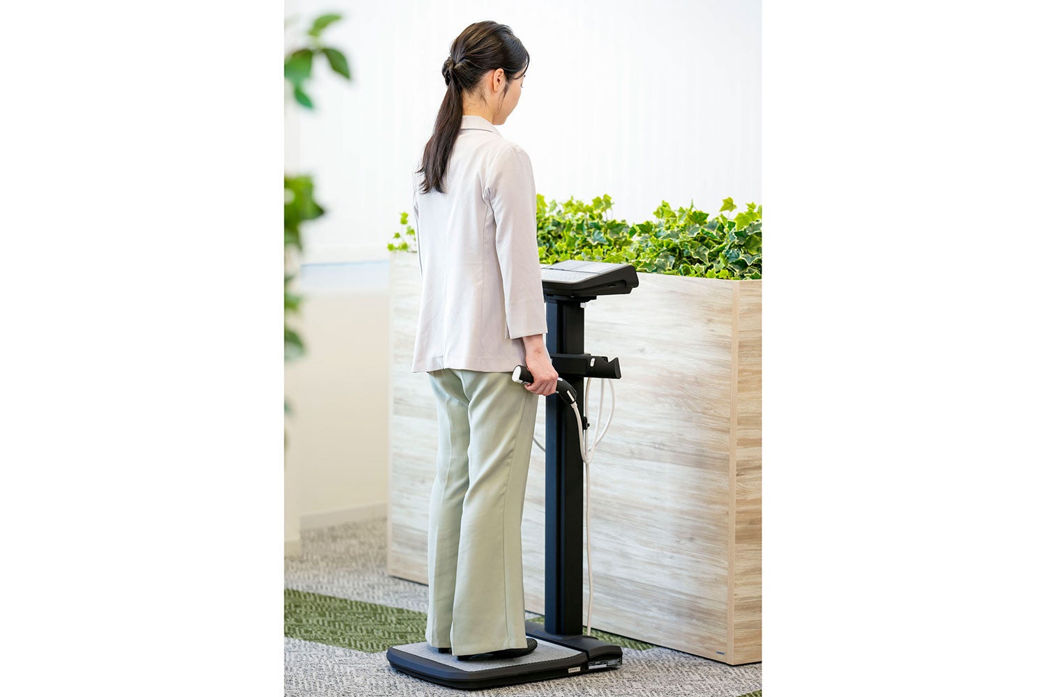 業務用体組成計を使用する女性の後ろ姿